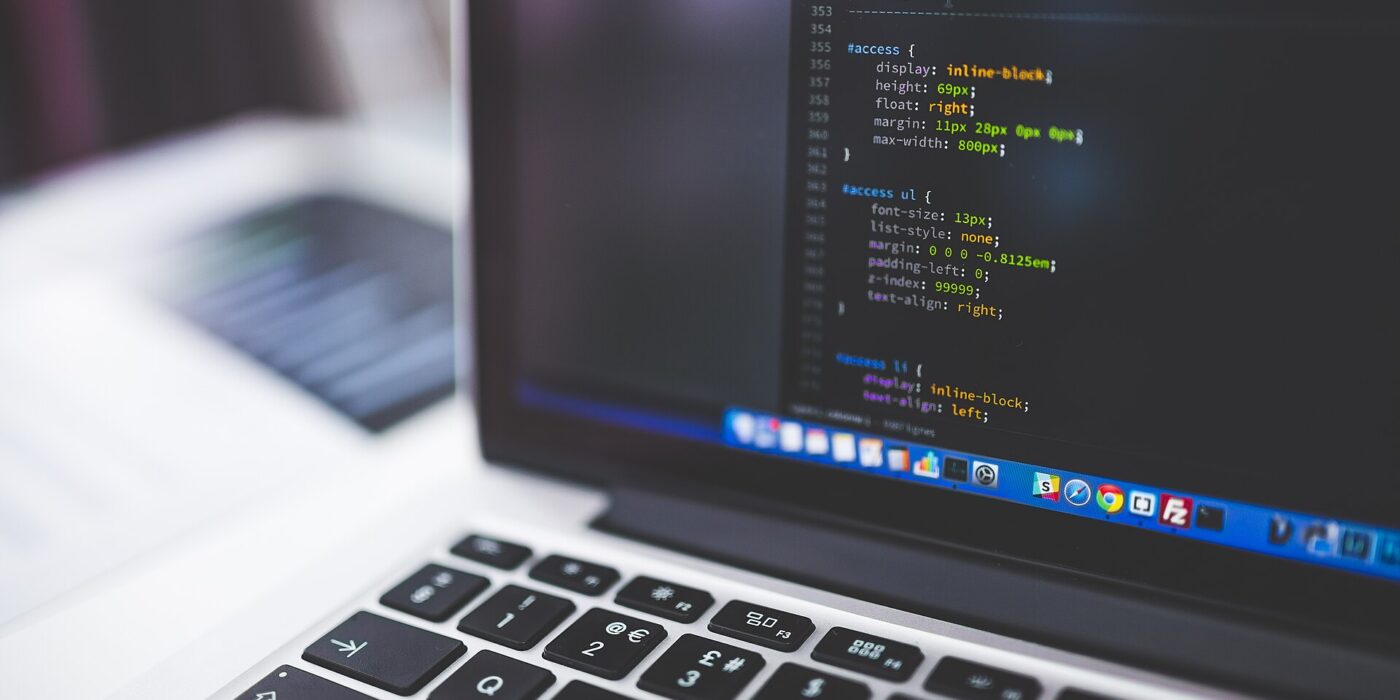 Laptop screen showing CSS code in a code editor, the kind of stylesheet where you write CSS container queries